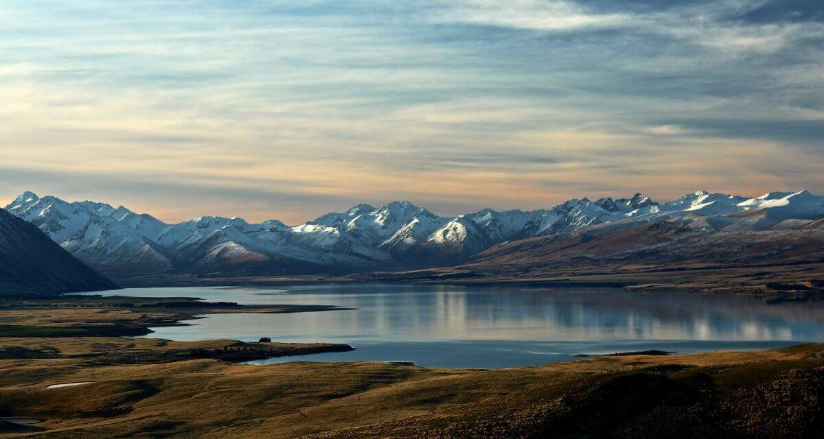 New Zealand Pilgrimage blog cover image mountains and shoreline in New Zealand for Wonder Voyage blog
