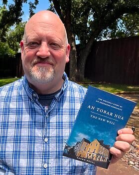 Author Shawn Small holds book about An Tobar Nua in Ireland