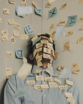 Business man covered in sticky notes