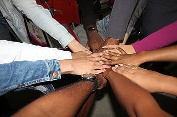 group of hands touching each other for Wonder Voyage blog about faith Based Student Travel