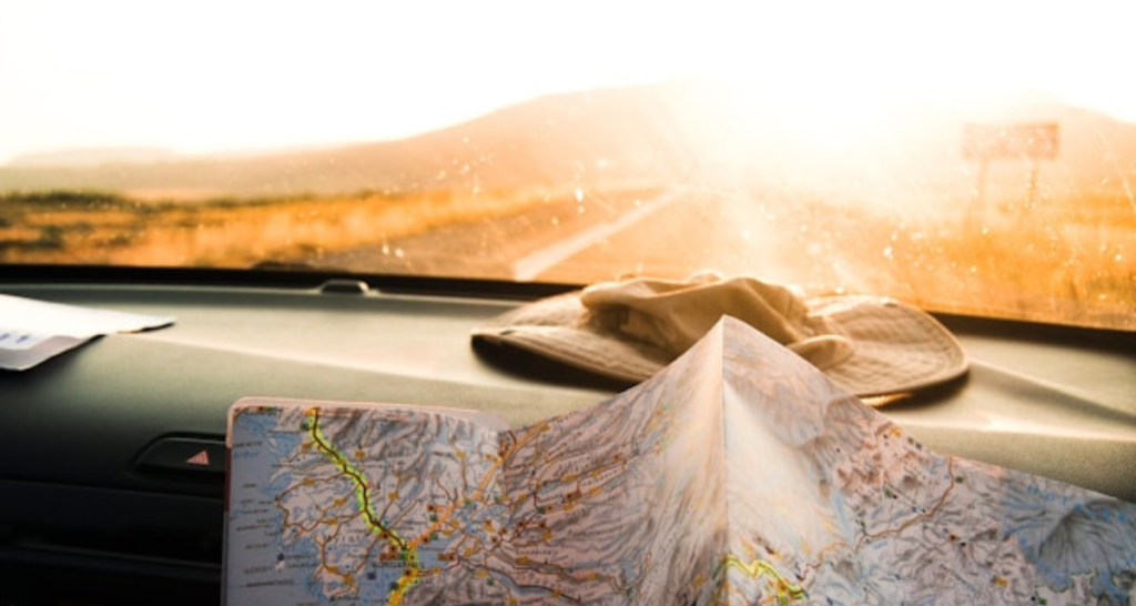 image of map and hat in van on roadtrip for Wonder Voyage blog about how to plan your 2027 pilgrimage