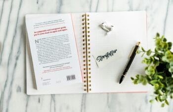 journal with pen, earbuds and sticker that says storyteller for blog about youth mission trip fundraising ideas