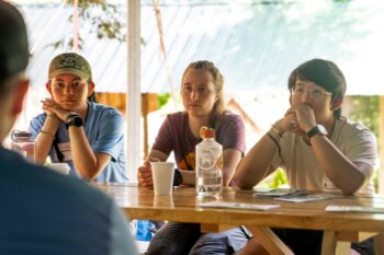 teens sitting at table for article about mission trip planning guide