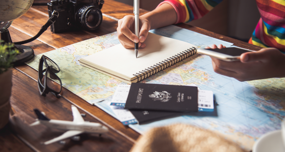 woman holding pen, notebook, phone, and passport for blog post about transformative mission trips woman holding pen, notebook, phone, and passport for blog post about planning a transformational mission trip