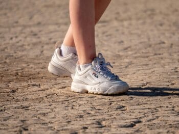 woman's feet with white tennis shoes on